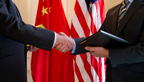  Two men, one from China and the other one from the USA, shaking hands 